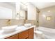 Modern bathroom featuring double vanity, vessel sinks, and stylish gold fixtures with tile surround bathtub at 1015 Churchman Ave, Indianapolis, IN 46203