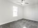 Bright bedroom features a ceiling fan, gray carpet and neutral walls, illuminated by a natural light from a window at 1015 Churchman Ave, Indianapolis, IN 46203