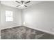 Bright bedroom features a ceiling fan, gray carpet and neutral walls, illuminated by a natural light from a window at 1015 Churchman Ave, Indianapolis, IN 46203