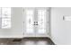 Bright entryway featuring decorative glass double doors, wood-look flooring, and white walls at 1015 Churchman Ave, Indianapolis, IN 46203