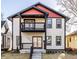 Two-story home with eye-catching red and black accents, a second story balcony, and covered entry porch at 1015 Churchman Ave, Indianapolis, IN 46203