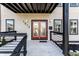 Charming covered front porch featuring a red double door with decorative glass panels and black railing at 1015 Churchman Ave, Indianapolis, IN 46203