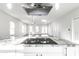 Kitchen island with granite countertop and cooktop, featuring a view of the open-concept living area at 1015 Churchman Ave, Indianapolis, IN 46203