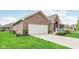 Charming brick home featuring a two-car garage, manicured lawn, and welcoming curb appeal at 5707 Kensington Blvd, Plainfield, IN 46168