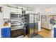 An inviting kitchen with stainless steel appliances and white cabinets, adjacent to an open-concept living area at 5707 Kensington Blvd, Plainfield, IN 46168
