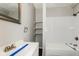 Updated bathroom with a modern vanity, open shelving, and bright white shower-tub combo at 5060 Staughton Dr, Indianapolis, IN 46226