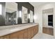 Modern bathroom featuring a dual sink vanity, sleek lighting, and a view of the glass shower at 5469 Harness Dr, Greenwood, IN 46143