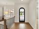 Bright foyer featuring hardwood floors, wrought iron railing, and a modern light fixture at 5469 Harness Dr, Greenwood, IN 46143