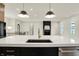 Bright kitchen with white countertop island, modern lighting, and black fireplace in the living room at 5469 Harness Dr, Greenwood, IN 46143