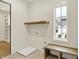 Bright laundry room with floating shelf, bench, and large window at 5469 Harness Dr, Greenwood, IN 46143