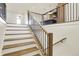 Elegant staircase with natural wood treads and black iron railings that seamlessly blend with the light interior at 5469 Harness Dr, Greenwood, IN 46143