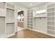 Spacious walk-in closet featuring custom shelves and drawers with a peek into a bathroom at 5469 Harness Dr, Greenwood, IN 46143