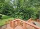 Multi-level wooden deck with stairs leading to the backyard, surrounded by mature trees and greenery at 620 Valley Dr, Martinsville, IN 46151