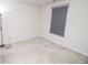 A carpeted bedroom has a window with a grey roller shade at 975 Red Hills Ct, Lebanon, IN 46052