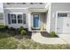 Close-up of a blue front door framed by manicured landscaping and a welcoming walkway at 975 Red Hills Ct, Lebanon, IN 46052