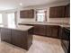 Well-lit kitchen featuring an island, dark cabinetry, and modern appliances at 975 Red Hills Ct, Lebanon, IN 46052