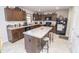 Charming kitchen with a kitchen island featuring a stone counter, dark wood cabinets, and modern appliances at 975 Red Hills Ct, Lebanon, IN 46052