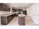 Kitchen with dark cabinets, modern appliances, kitchen island, and tile flooring, showcasing functionality at 975 Red Hills Ct, Lebanon, IN 46052