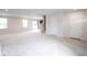 Spacious living area with neutral carpet, staircase, multiple windows, and a walk-out sliding door at 975 Red Hills Ct, Lebanon, IN 46052