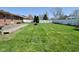 Expansive backyard with a wooden deck, manicured lawn, fire pit and a privacy fence at 409 Dale St, Martinsville, IN 46151