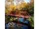 Charming bridge surrounded by vibrant fall foliage and reflective water, creating a picturesque outdoor scene at 4325 Hamilton Run, Zionsville, IN 46077