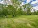 Expansive backyard featuring a lush lawn and mature trees, great for outdoor activities at 5784 N 600 E, Greenfield, IN 46140