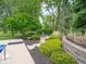 Inviting backyard fire pit area with stone pavers surrounded by lush greenery and manicured landscaping at 5784 N 600 E, Greenfield, IN 46140