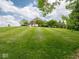 Expansive backyard view showcasing a lush lawn, mature trees, and the home's exterior at 5784 N 600 E, Greenfield, IN 46140