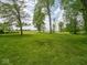 Spacious backyard featuring a lush lawn and mature trees, perfect for recreation and relaxation at 5784 N 600 E, Greenfield, IN 46140