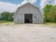 A view of a large gray barn with sliding doors, showcasing its size and potential uses at 5784 N 600 E, Greenfield, IN 46140