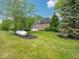 Beautiful home exterior with lush landscaping, mature trees, and solar panels on the roof at 5784 N 600 E, Greenfield, IN 46140