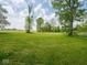 Expansive green field surrounded by mature trees under a cloudy sky at 5784 N 600 E, Greenfield, IN 46140