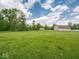 Expansive lush green field and barn under a bright, partly cloudy sky at 5784 N 600 E, Greenfield, IN 46140