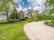 Landscaped front yard with a circular driveway and mature trees at 5784 N 600 E, Greenfield, IN 46140