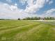 Expansive green field featuring a long driveway and white fencing at 5784 N 600 E, Greenfield, IN 46140