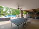 Outdoor patio with ping pong table, lounge seating, string lights, and a clear view of the pool at 5784 N 600 E, Greenfield, IN 46140