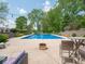 Large in-ground pool with lounge seating, an umbrella-covered seating area, and green landscaping at 5784 N 600 E, Greenfield, IN 46140
