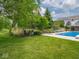 Beautiful in-ground pool with manicured landscaping and trees surrounding the perimeter of the backyard at 5784 N 600 E, Greenfield, IN 46140
