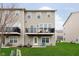 Back exterior view of townhome with balconies and a well-manicured lawn at 7282 Zanesville Rd, Carmel, IN 46033