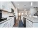 Modern kitchen with white cabinetry, stainless steel appliances, and a view into the adjacent living spaces at 7282 Zanesville Rd, Carmel, IN 46033