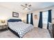 Cozy main bedroom featuring carpet floors, a ceiling fan, and a large window with blue curtains at 7282 Zanesville Rd, Carmel, IN 46033