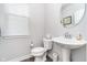 Clean powder room featuring a pedestal sink, round mirror, and light neutral paint at 7282 Zanesville Rd, Carmel, IN 46033