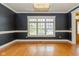 Dining room featuring hardwood floors, chair railing, elegant dark walls, and a stylish light fixture at 7290 Lockford Walk N, Avon, IN 46123
