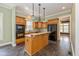 Traditional kitchen featuring wood cabinetry, an island with seating, and black appliances at 7290 Lockford Walk N, Avon, IN 46123