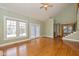 Bright living room with gleaming hardwood floors and large windows. Staircase and entry visible at 7290 Lockford Walk N, Avon, IN 46123