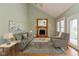 Inviting living room with a fireplace, neutral-toned furniture, and natural light from the large windows at 7290 Lockford Walk N, Avon, IN 46123