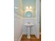 A charming powder room with pedestal sink, wainscoting, and decorative mirror at 7290 Lockford Walk N, Avon, IN 46123