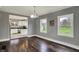 Dining room with hardwood floors, neutral walls, and a glimpse into the kitchen at 8240 Shelbyville Rd, Indianapolis, IN 46259