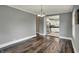 Open-concept dining room featuring hardwood floors and a view into the modern, white kitchen at 8240 Shelbyville Rd, Indianapolis, IN 46259