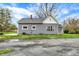 Rear exterior view of a gray house showcasing the roof, siding, and surrounding yard at 8240 Shelbyville Rd, Indianapolis, IN 46259